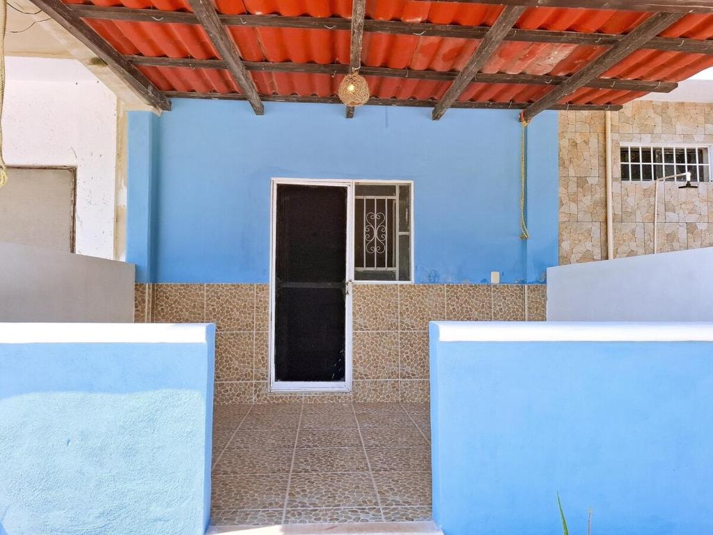Habitación con pared azul y puerta en Casa Jedidian, en El Cuyo