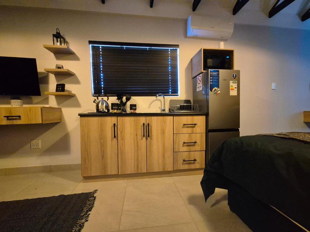 cocina con fregadero, nevera y ventana en At-Nine, en Welkom