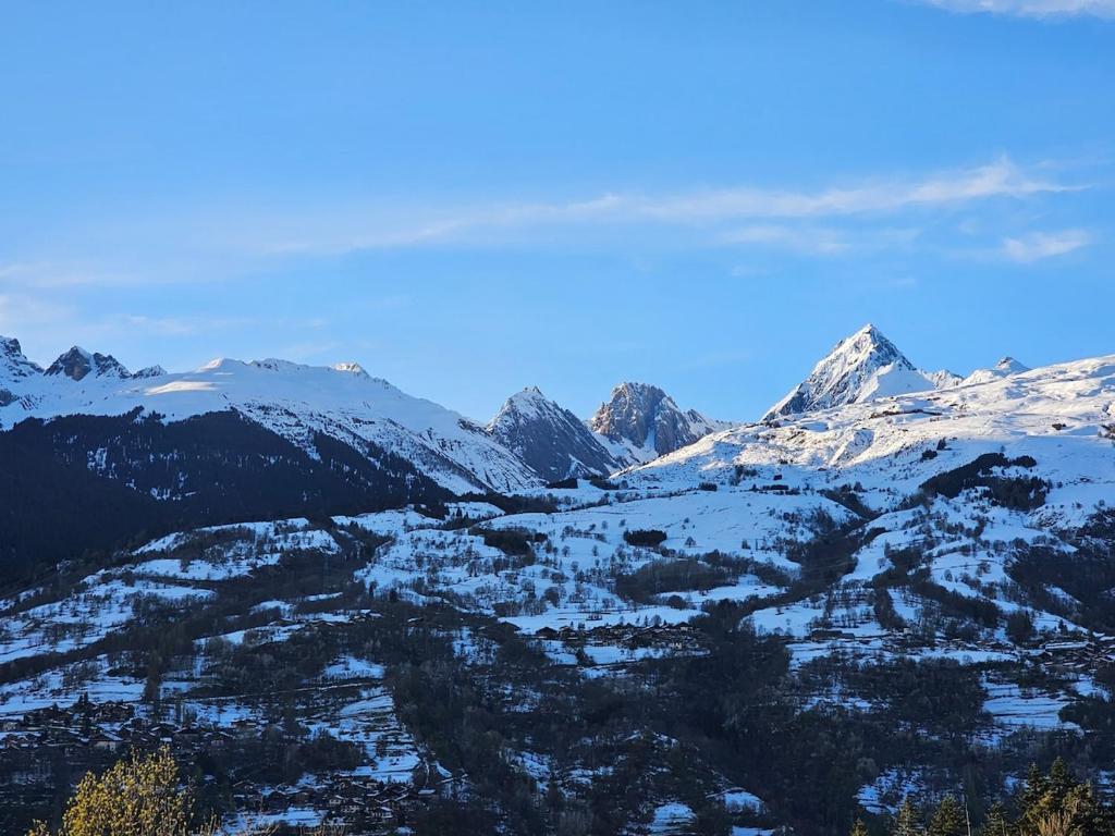 una cordillera cubierta de nieve con montañas de fondo en Chalet coeur d'alpage La Plagne Les Arcs, en La Plagne Tarentaise