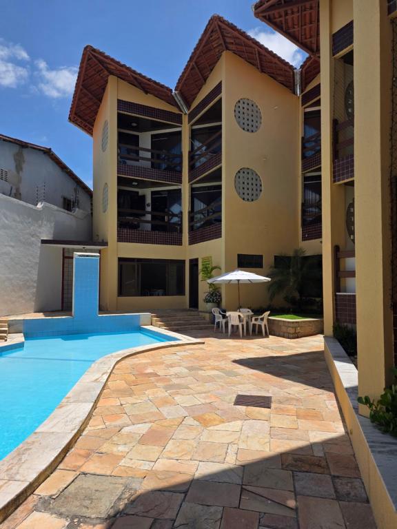 a villa with a swimming pool and a patio at Varandas de Pirangi in Parnamirim
