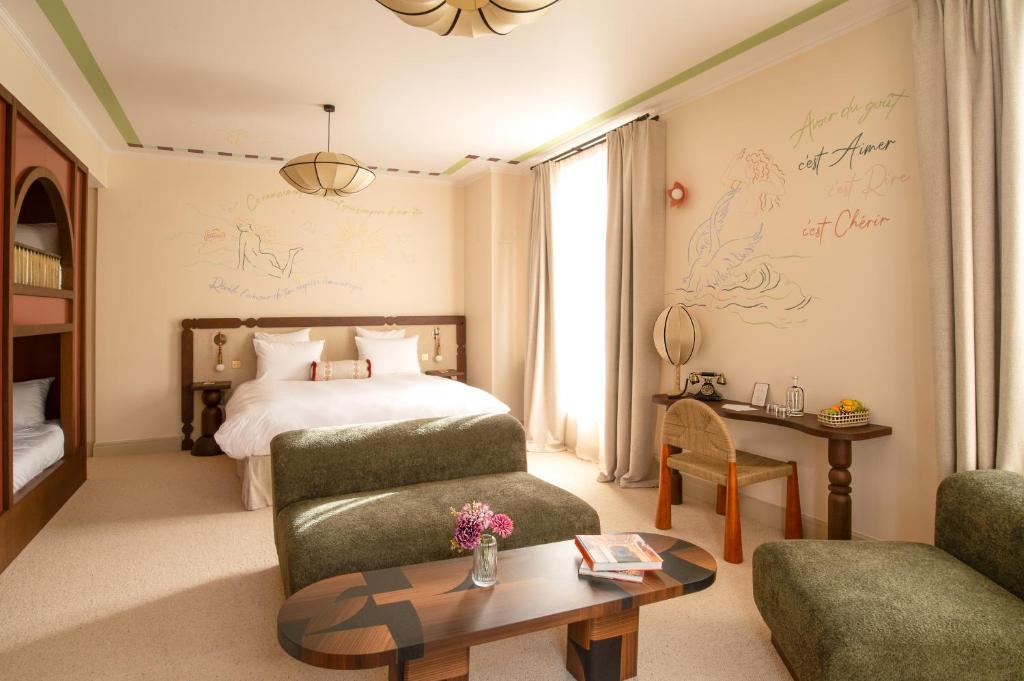 a bedroom with a bed and a couch and a table at Verneuil la douce in Verneuil d'Avre et d'Iton