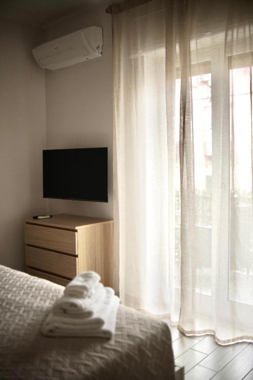 a bedroom with a bed and a tv and a window at Parthenope Luxury Apartment in Naples