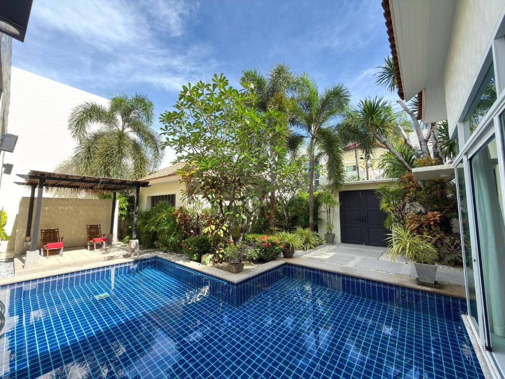 a swimming pool in front of a house at Villa 4 BD Nai Harn Beach by Mill in Ban Saiyuan (1)