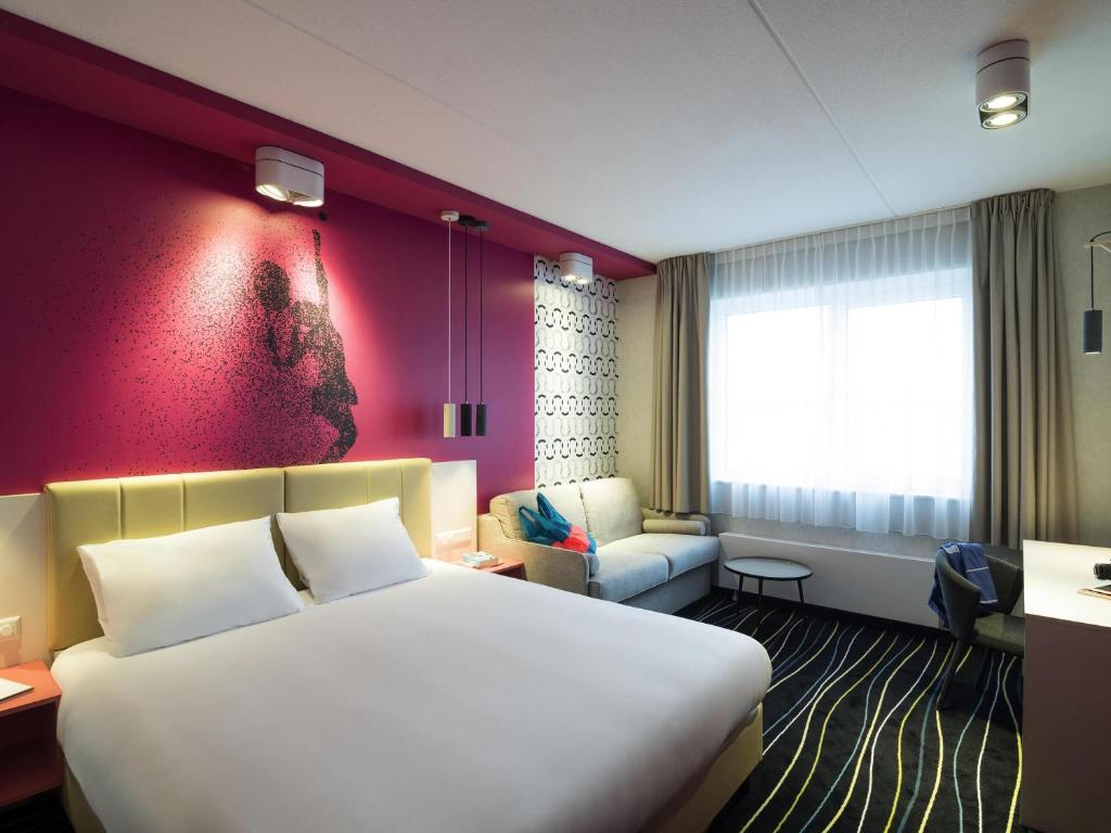 una camera d'albergo con un letto grande e un divano di ibis Styles Haarlem City a Haarlem