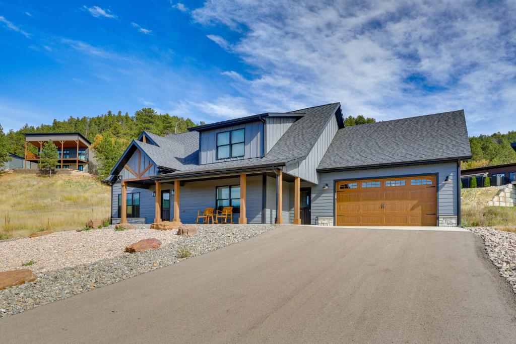 a house with a gray roof and a garage at Luxe, New-Build Sturgis Retreat with Mountain Views in Crook City