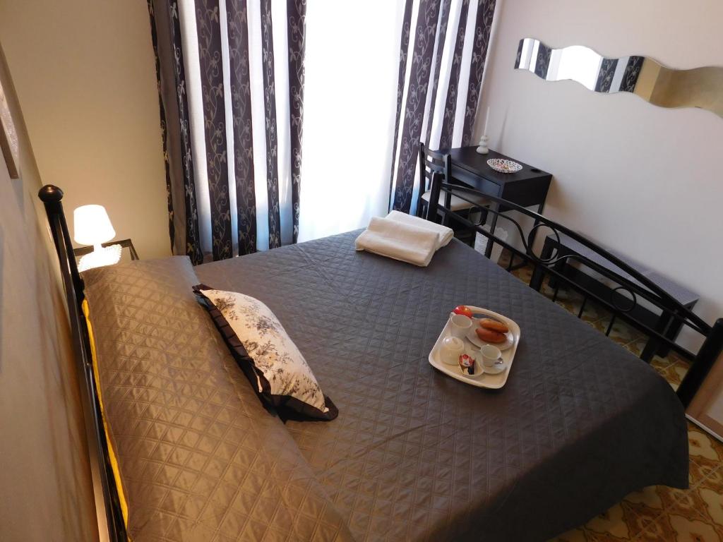 Una cama con una bandeja de comida encima. en B&B Affittacamere La Dolce Mela, en Francavilla di Sicilia