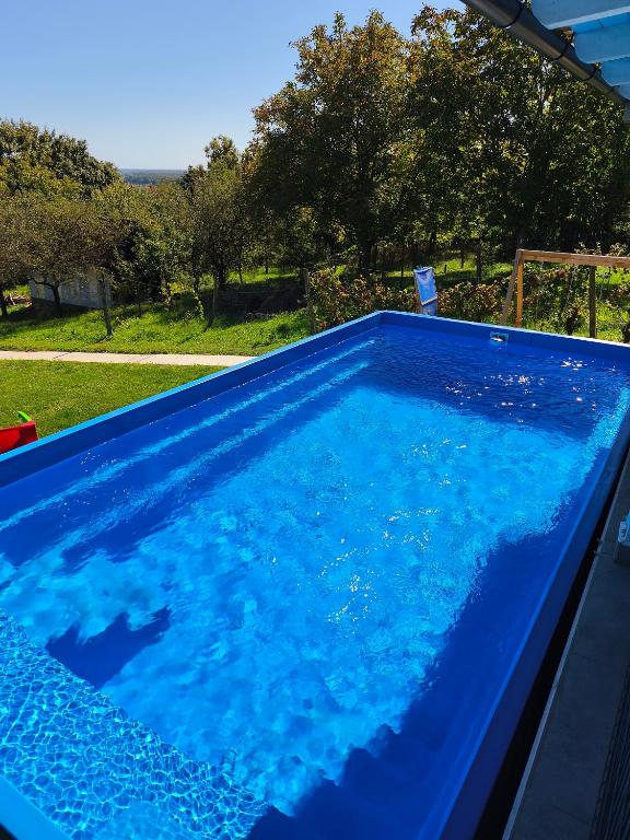 a swimming pool with blue water in a yard at Family House Roza in Gračec