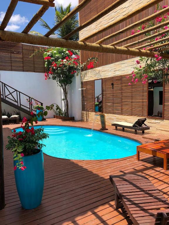 a swimming pool on a wooden deck with flowers at Villa Puglia Jeri in Jericoacoara