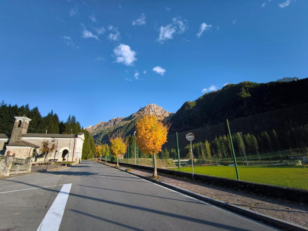 an empty street with a mountain in the background at GREEN DOLOMYTE Apartment in Schilpario
