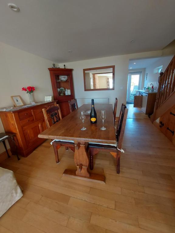 einen Esstisch mit einer Flasche Wein darauf in der Unterkunft Coastline cottage in Pakefield