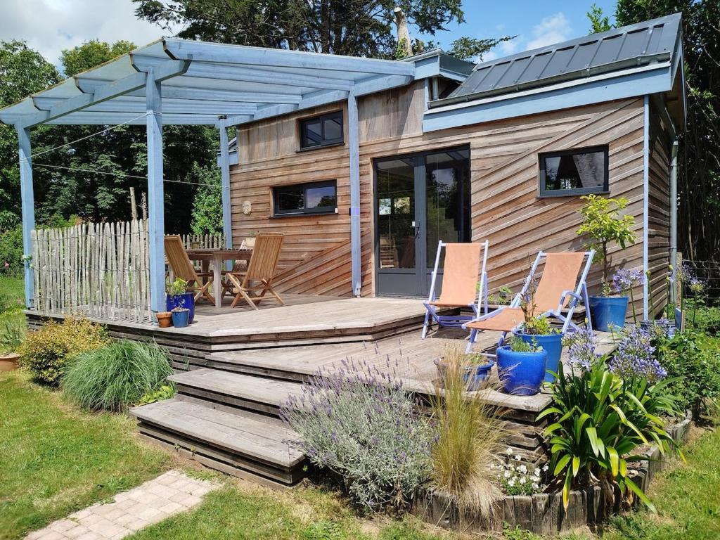 a tiny house with a wooden deck and a gazebo at Tinyhouse, winter cocoon, quiet and nature in Languidic