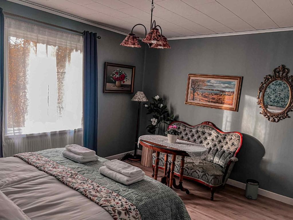 a bedroom with a bed and a table and a chair at Daisy's Home Vimmerby in Vimmerby