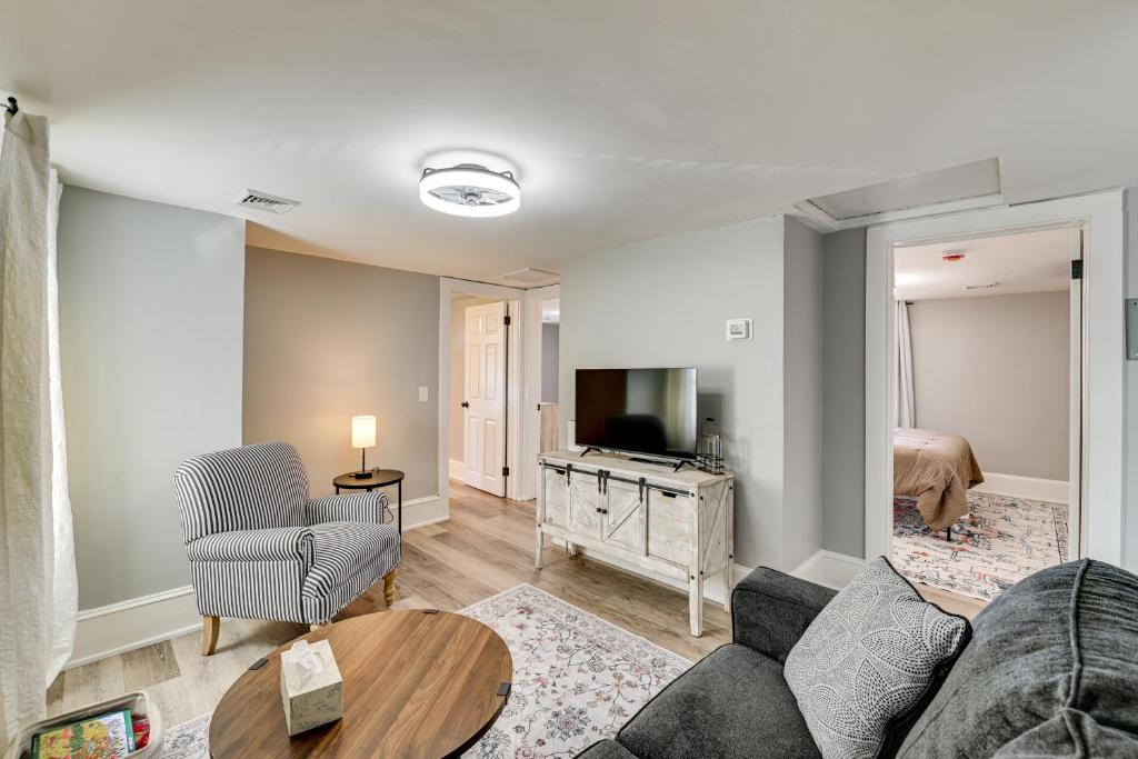 Una sala de estar con un sofá, un televisor y una cama. en 2 Mi to Uptown Centrally Located Kingston Apt!, en Kingston