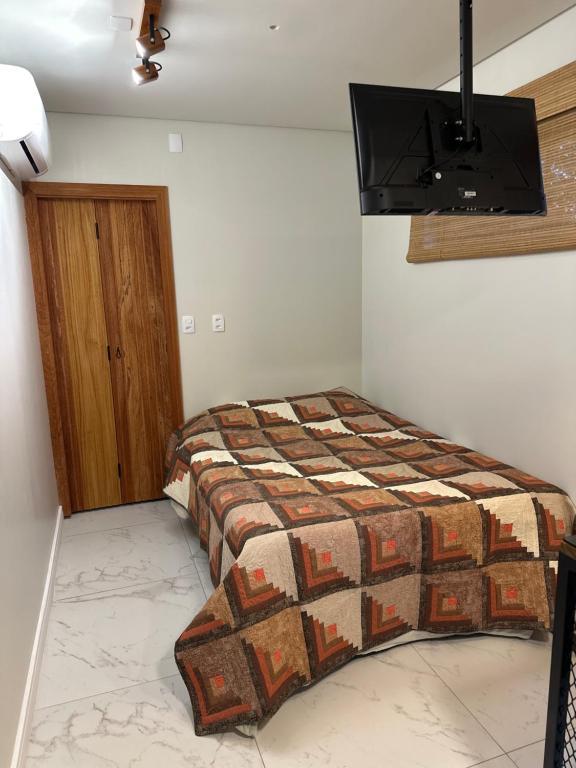 a bedroom with a bed and a television on the wall at Containersblack in Florianópolis