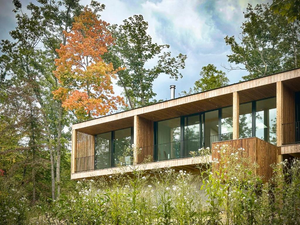a wooden house in the woods with trees at Será at Sandy Ridge - Brand New Modern WV Retreat in Wardensville