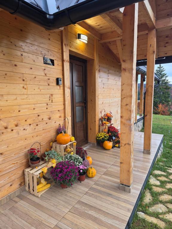 a porch of a wooden house with pumpkins and flowers at Brvnara Relax in Sekulić 