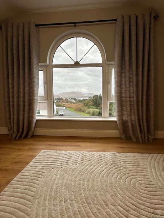 a room with a large window with a large rug at Conors view in Annagry