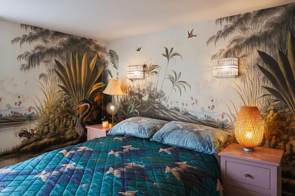a bedroom with a bed with a tropical wallpaper at Artists Hideaway in Cowfold