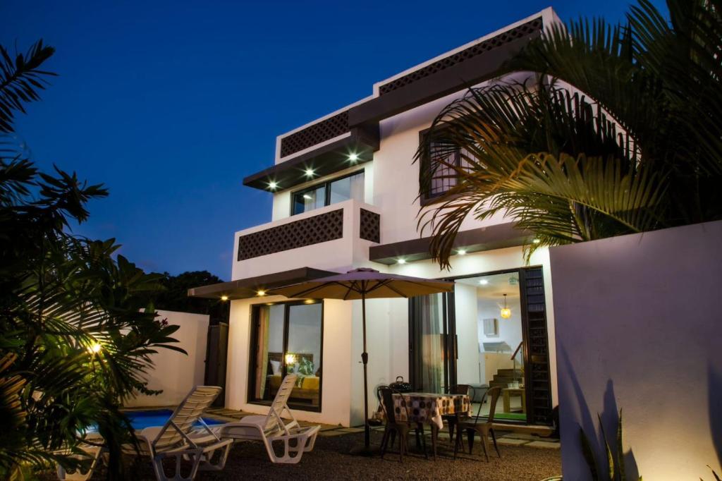 een huis met een paraplu en een tafel en stoelen bij The marbella villas 2 in Grand Baie