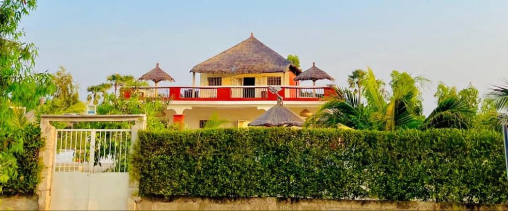 a house with a red roof and a hedge at Résidence Le Marlodj in Mar Lodj