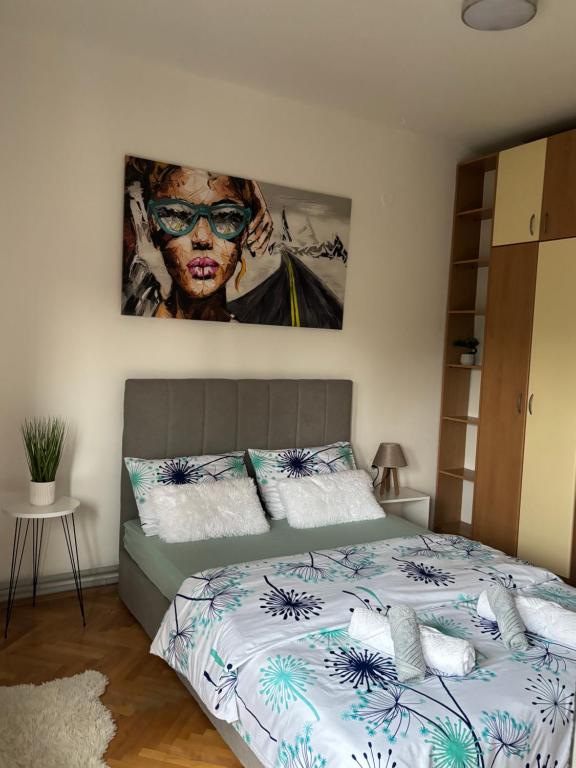 a bedroom with a bed with a painting on the wall at Comfort corner in Skopje