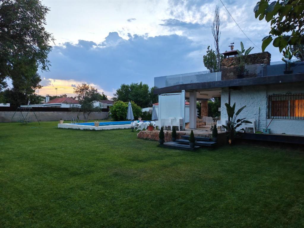 a house with a yard with a grass field at Chalet Las Rosas in Albacete