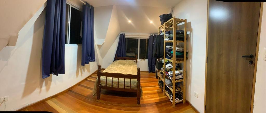 un pasillo con una habitación con una estantería de zapatos en Chalé Vila Rica, en Campos do Jordão
