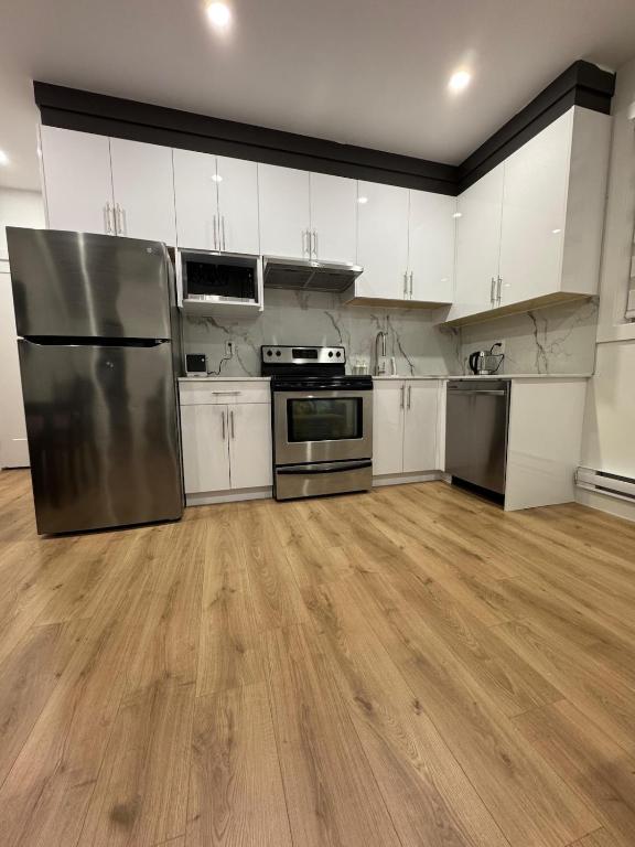 a kitchen with stainless steel appliances and white cabinets at Brand new fully Private Garden Suite in Delta