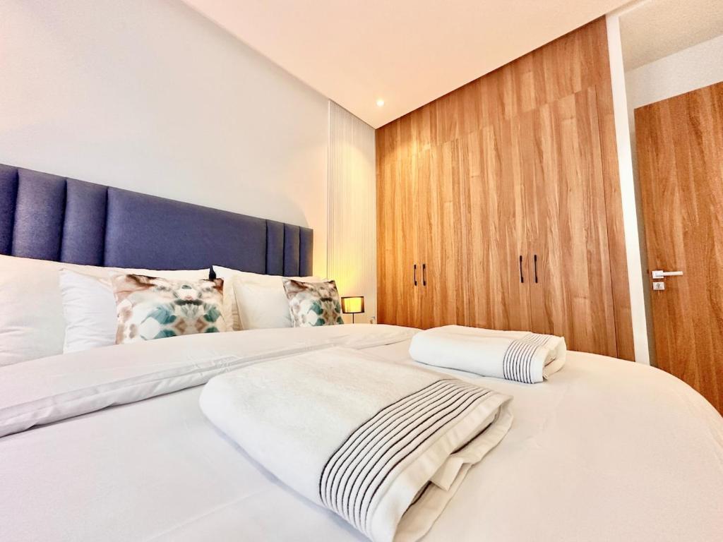 カサブランカにあるCozy, Elegant Apartment, Parking and Fiberのベッドルーム(青いヘッドボード付きの白い大型ベッド1台付)