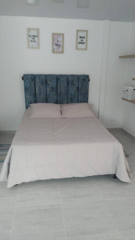 a large bed with a blue headboard in a bedroom at Buga home in Buga