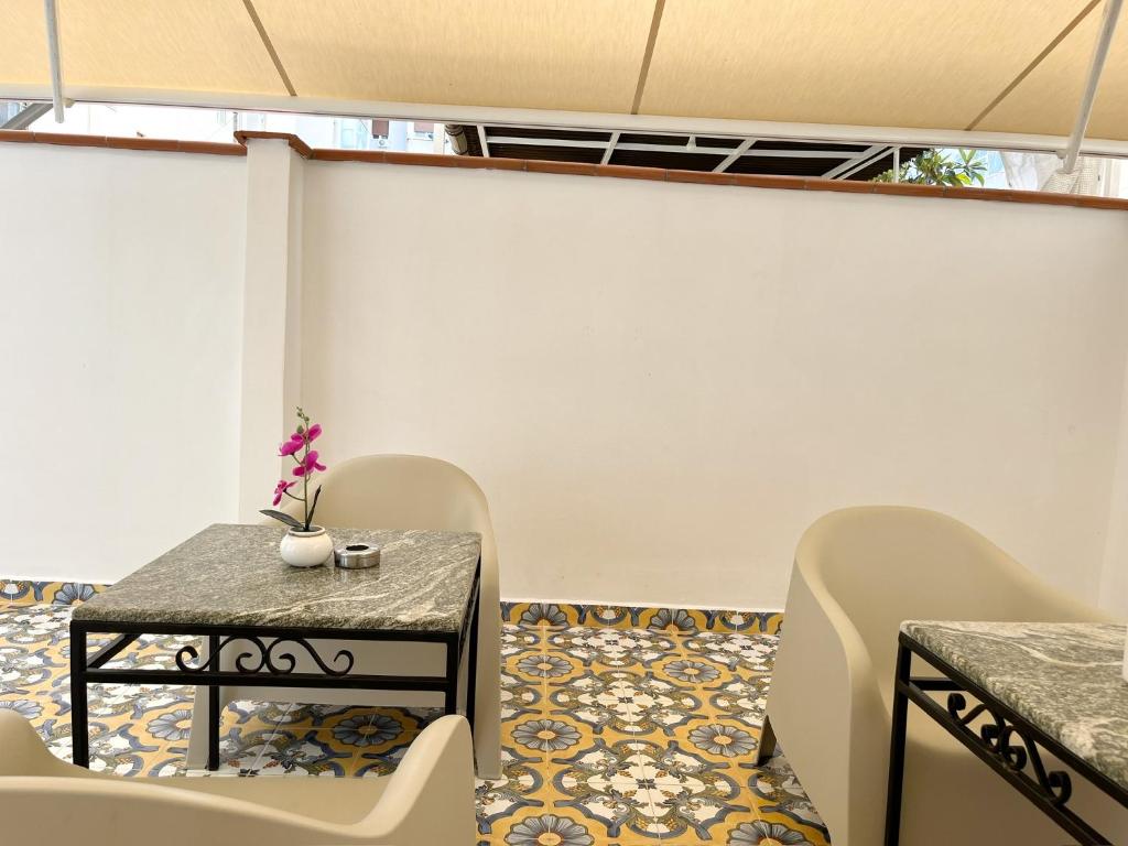 Una habitación con una mesa y sillas y un suelo de baldosas. en Palermo central stay, en Palermo