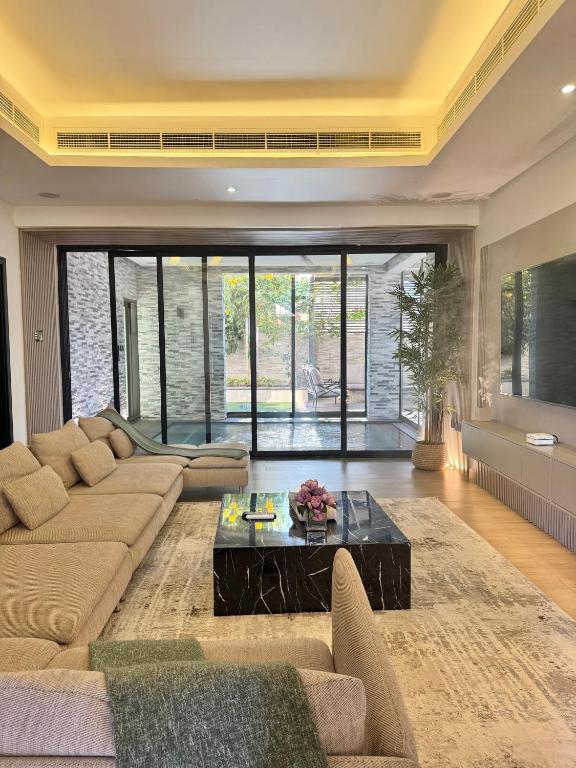 阿吉曼AB Villa - Pool & Cinema的客厅里有一张沙发和一张咖啡桌。