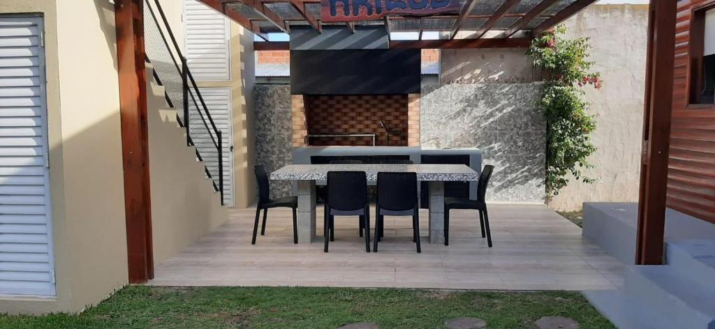 a dining table and chairs on a patio at Complejo Junior in San Clemente del Tuyu