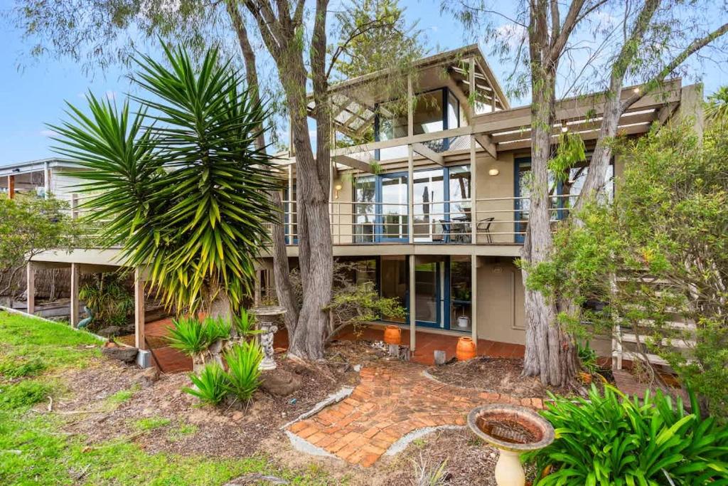 einen Blick nach außen auf ein großes Haus mit Bäumen in der Unterkunft Private Access to Beach Oceanview with Home Gym in Cowes