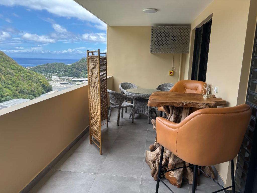 Un balcón con mesa y sillas y vista al mar. en Zen escape-ocean view Papeete, en Papeete