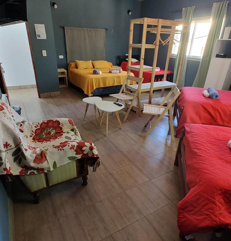 a room with two beds and a bed and chairs at Raíces Hospedaje in Humahuaca