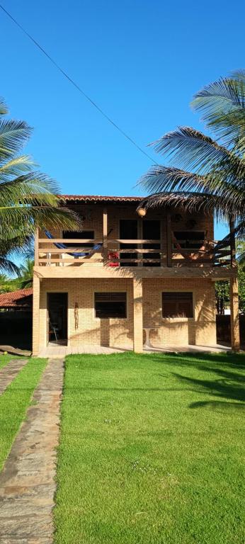 un bâtiment avec des palmiers en face d'une cour dans l'établissement casa de praia a beira mar, à Campina
