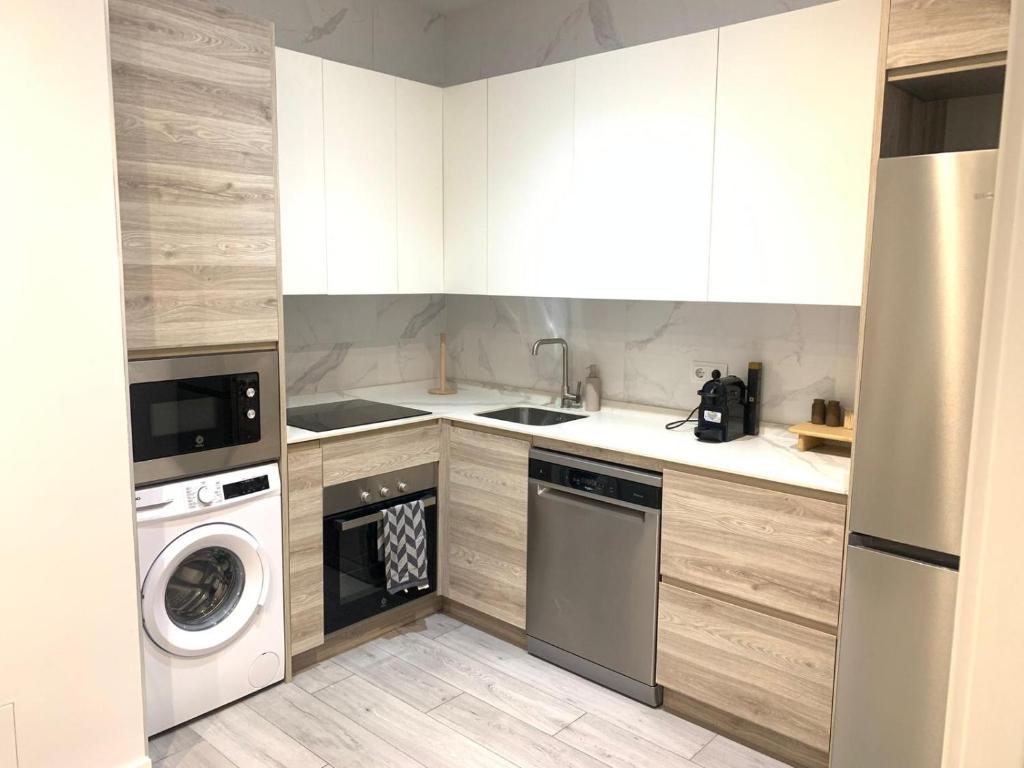 a kitchen with a washing machine and a washer at Urban Suites Aluche in Madrid