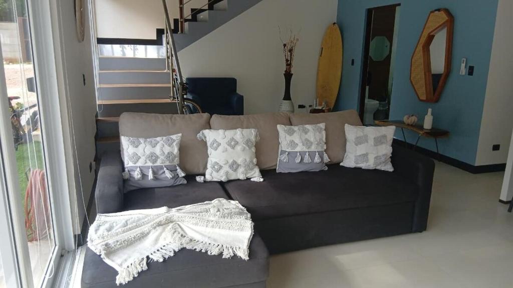 sala de estar con sofá marrón con almohadas en Loft en San José de pinilla avellanas guanacaste, en San José Pinilla