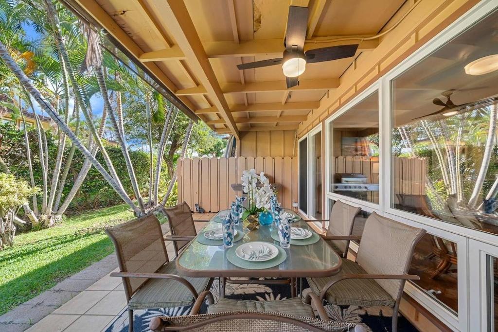 a patio with a table and chairs on a porch at Puamana 153-4 · PU 153-4 Spacious Puamana Unit & Walk To The Bea in Lahaina
