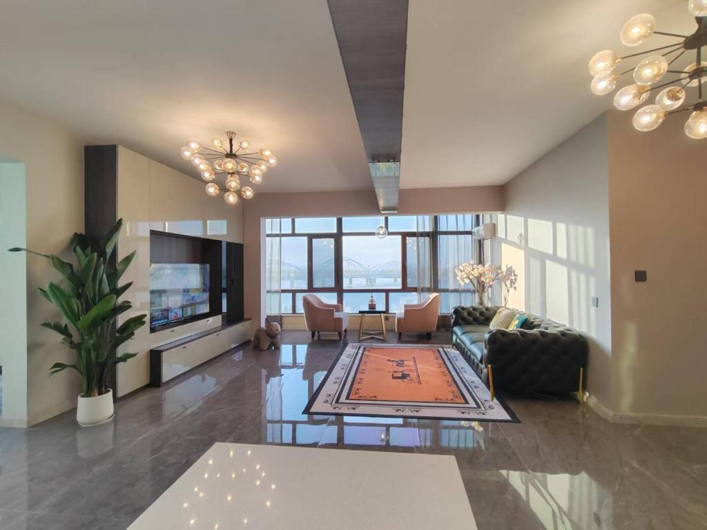 una sala de estar con un sofá y una mesa en Central Avenue Luxury River View Apartment, en Harbin
