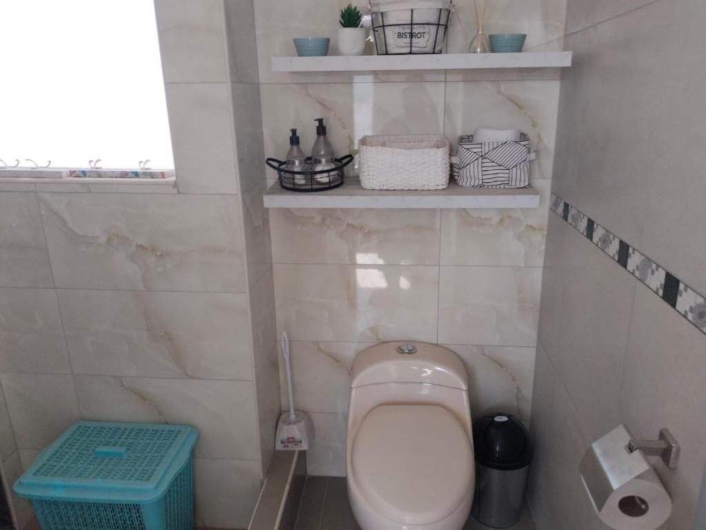 a small bathroom with a toilet and some shelves at Apartamento in Arequipa