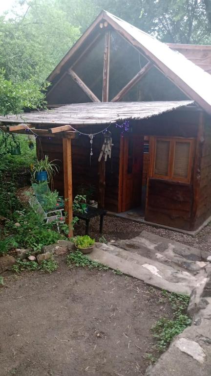 a small wooden cabin with a white roof at Cabaña El Poeta in Cuesta Blanca
