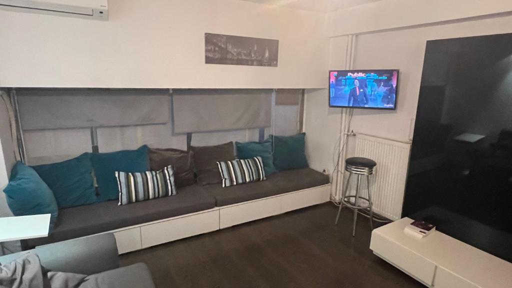 Una sala de estar con un sofá y un televisor. en Loft for 4 to the center of Thessaloniki, en Tesalónica