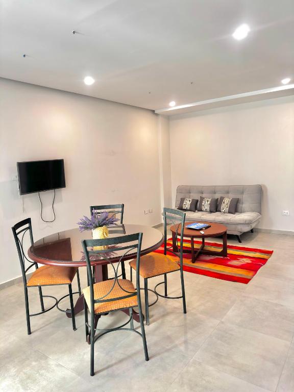 un salon avec une table, des chaises et un canapé dans l'établissement El Molino Apartment, à Tarija