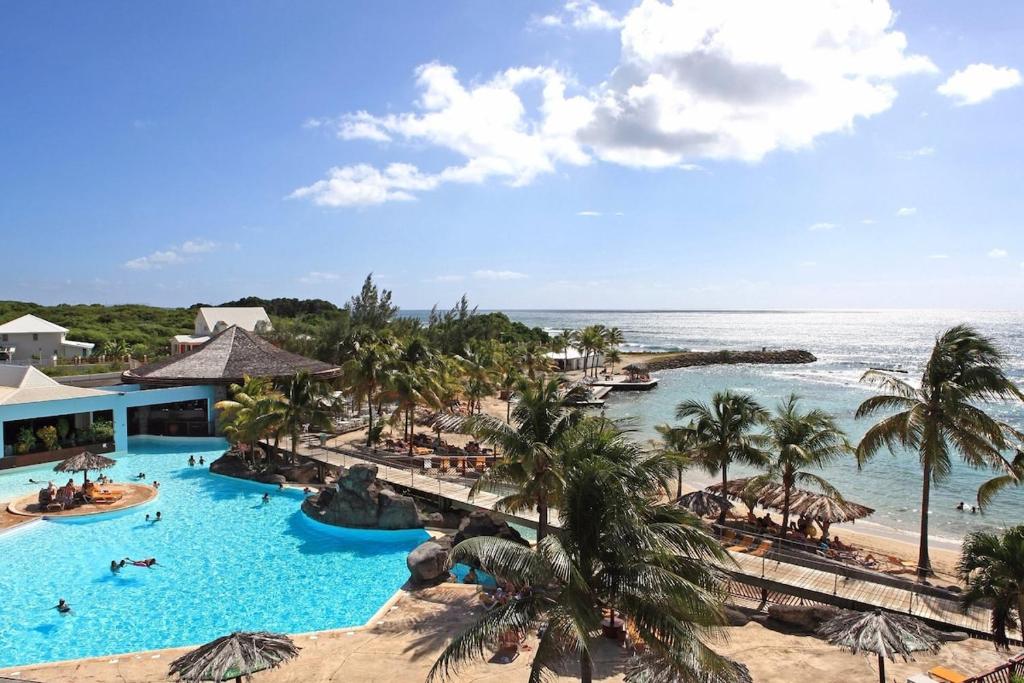an aerial view of a resort with a pool and the ocean at Morphée Lodge in Saint-François