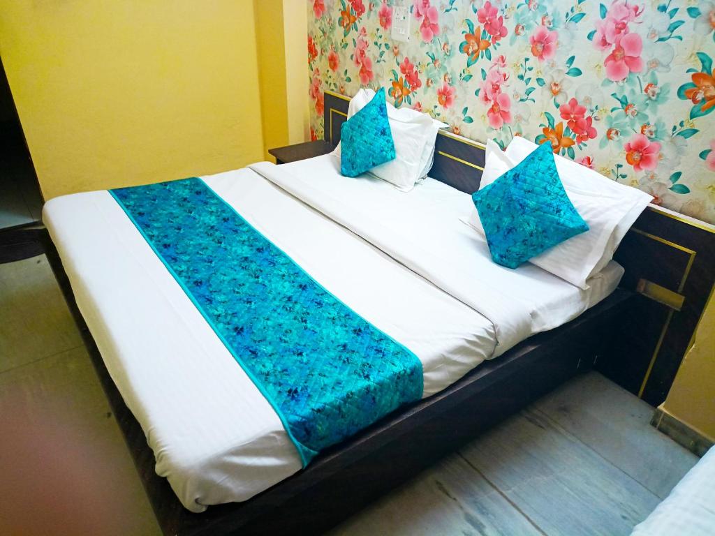Bett in einem Zimmer mit blauen Kissen darauf in der Unterkunft Hotel Surya Mahal in Jaipur
