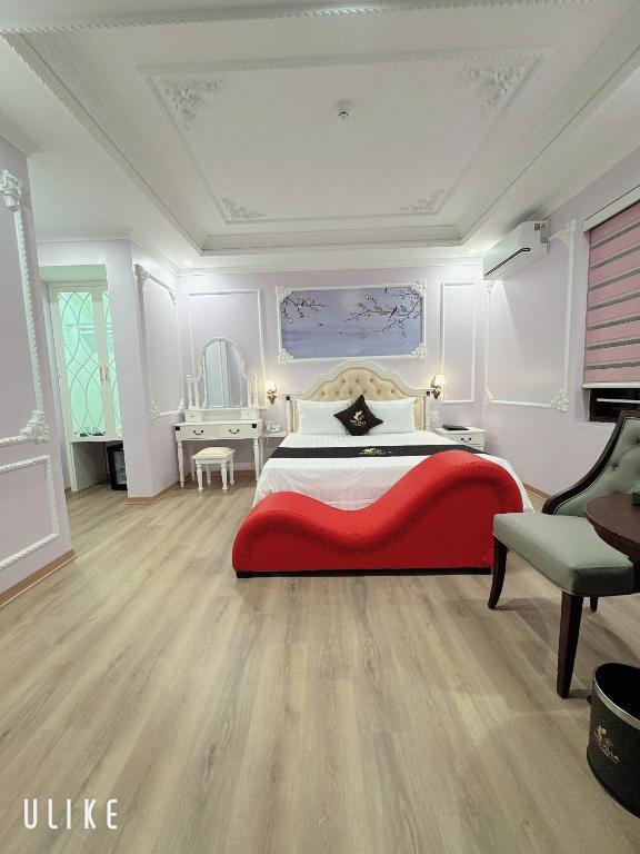 a bedroom with a red bed and a chair at One Villa Hotel 6 in Long Biên