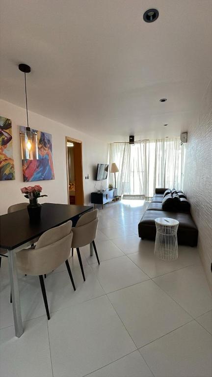 a living room with a couch and a table and chairs at Apartamentos Esperança in Sal Rei