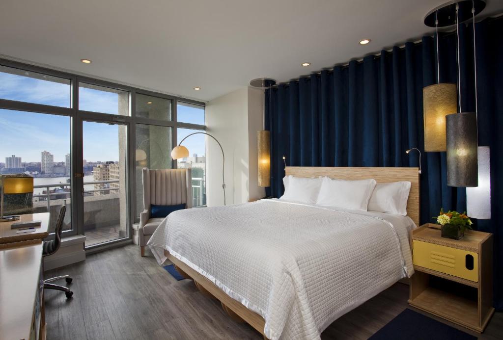 
a hotel room with a large bed and a large window at Arthouse Hotel in New York
